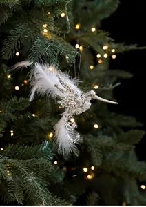 Detail of silver hummingbird ornament with sequins and white feathers on Christmas tree