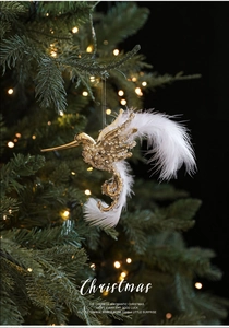 Close-up of golden hummingbird ornament with crystals and feathers on Christmas tree