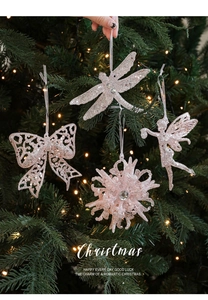 Pink glitter Christmas ornaments including snowflakes and bows on a glowing Xmas tree