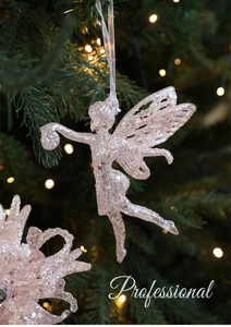 Detailed close-up of a pink glitter fairy ornament hanging on a green Christmas tree