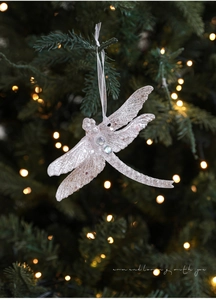 Glittery dragonfly Christmas tree ornament with gems and white ribbon on pine branch