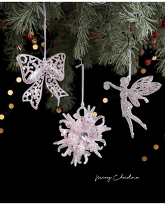 Pink glitter Christmas tree ornaments with snowflakes and bows hanging on branches