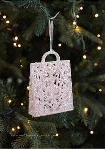 Detail of pink glitter handbag Christmas ornament with hollow design on tree branch