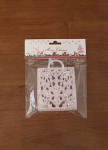 Close-up of pink glitter Christmas tree ornament with intricate hollow bag design
