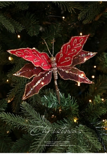 Detailed view of red mesh butterfly ornament with gold glitter clipped on a Christmas tree