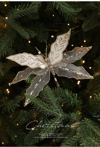 Detail of Christmas butterfly clip with mesh wings and sequins on a festive pine tree