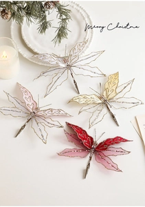 Detail view of mesh Christmas butterfly clips with sequins and beads on white tabletop