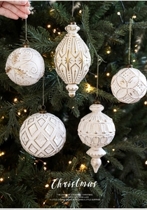 Details von weiß-goldenen Vintage-Weihnachtskugeln an einem warm beleuchteten Baum