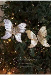 Detail of velvet Christmas butterfly clips with gold glitter and rhinestones on a tree