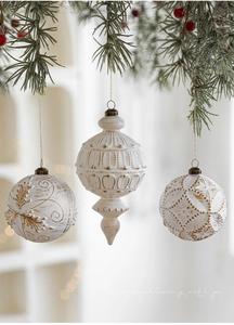 Nahaufnahme von weißen und goldenen Vintage-Weihnachtskugeln an einem festlichen Tannenzweig