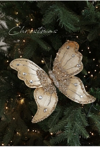 Close-up of golden Christmas bow with silver glitter and rhinestones on tree branch