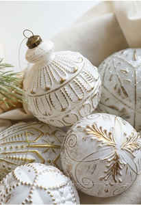 Makro-Detail von Vintage-Weihnachtskugeln in Off-White mit goldenem Reliefmuster