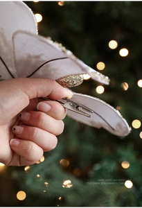 Close-up of white velvet Christmas butterfly bow with glitter edges and metal clip