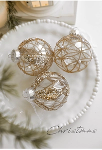 Detail of 8cm transparent Christmas balls with gold glitter patterns and pearl accents