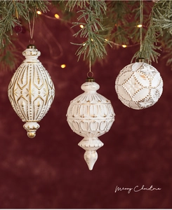 Nahaufnahme von weißen und goldenen Weihnachtsanhängern an einem Tannenzweig