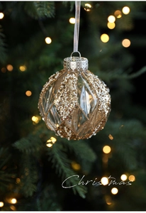 Detail of 8cm clear Christmas ball with gold sequins and beads on a festive tree branch