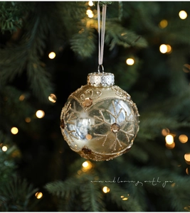 Detail of 8cm clear Christmas ball ornament with golden glitter snowflakes and gemstones