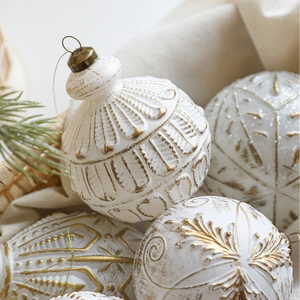 Vintage-Weihnachtskugeln in Weiß und Gold mit Reliefmuster und grünen Kiefernzweigen