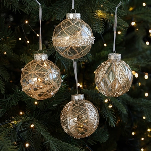 Set of four 8cm clear Christmas ball ornaments with gold glitter and pearls on tree