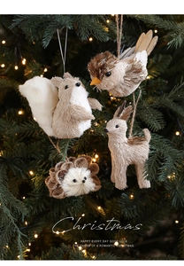 Detail von Tieranhängern aus Stroh am beleuchteten Weihnachtsbaum für Dekoration