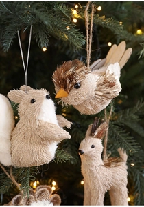 Detail von strohgewebten Waldtier-Anhängern an einem beleuchteten Weihnachtsbaum