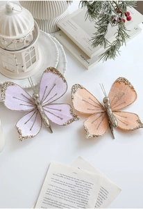 Close-up of velvet butterfly clips with pearls and gold glitter for Christmas decor