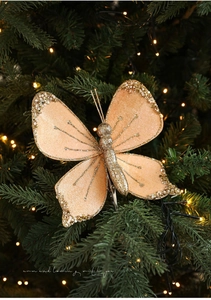 Detail of velvet Christmas butterfly clip with gold glitter and pearls on tree branches