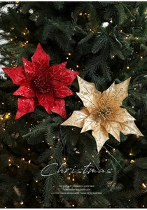 Close-up of red and gold sequined Christmas poinsettia flowers on a pine tree