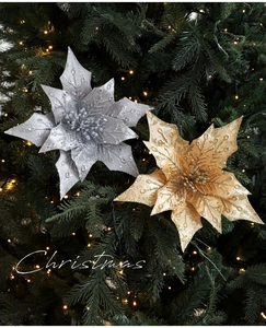 Close-up of sparkling gold and silver artificial poinsettia flowers on Christmas tree