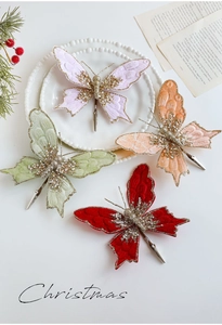 Nahaufnahme von Samt-Schmetterlingsclips mit Goldglitzer und Perlen für Weihnachtsdeko