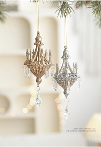 Detailed close-up of gold and silver glitter chandelier ornaments with crystal pendants
