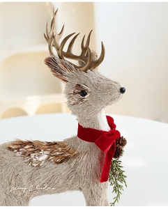 Detail of Christmas reindeer figurine made of sisal with red bow and small pine cones