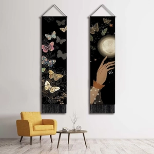 Detail of butterfly wall tapestries with tassels and vintage artistic patterns on white wall