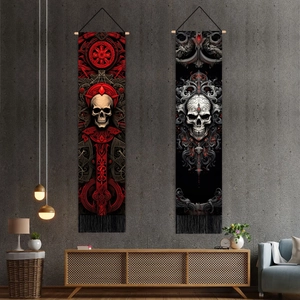 Gothic skull wall tapestries with wooden hangers and black fringe on a dark wall