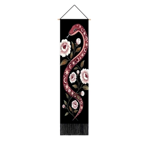 Detalle de tapiz de pared con serpiente y flores, barra de madera y borla negra