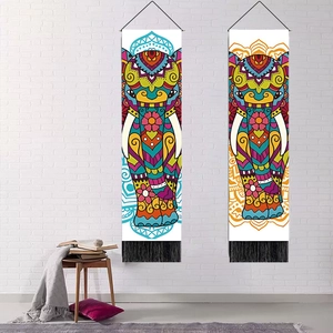 Bohemian elephant mandala tapestry set with fringe on a white brick wall background