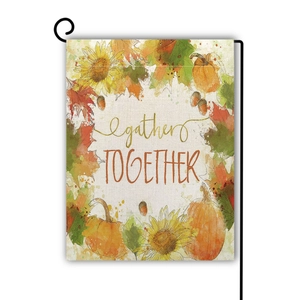 Detail of linen garden flag with pumpkins and sunflowers hanging on a black metal stand