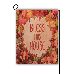 Detail of linen garden flag with autumn pumpkin and Bless This House text on black metal stand