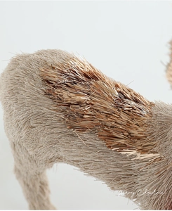 Macro detail of reindeer decor showing sisal straw texture and golden metallic accents