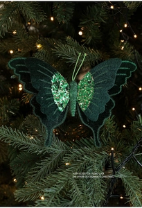 Dettaglio farfalla di velluto verde scuro con paillettes dorate su albero di Natale