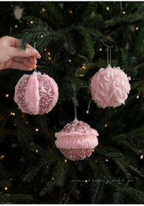 Detailed view of pink plush Christmas balls with pearls and sequins on a festive tree