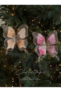 Détail d'ornements papillons en velours champagne et rose sur un sapin de Noël