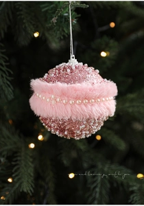 Close-up of pink Christmas ball with sequins, faux fur trim, and pearl bead details