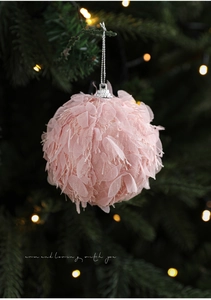 Detailed view of a pink plush Christmas ball ornament with soft petals on a festive tree