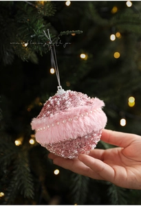 Detail of pink plush Christmas ball with sequins and white pearls on tree branches