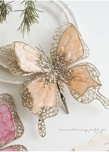 Détail d'un nœud en velours champagne avec filet doré pailleté et accents de perles