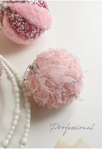 Detailed macro view of pink plush and mesh petal Christmas baubles with silver hanging loop