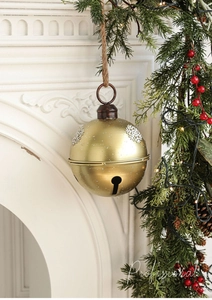 Detail of vintage gold Christmas bell with snowflake relief and rustic hemp rope