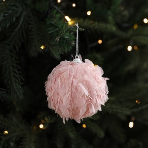 Elegant pink tulle Christmas ball ornament with silver cap hanging on a decorated tree