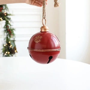 Large red metal Christmas bell with golden snowflake patterns and jute rope